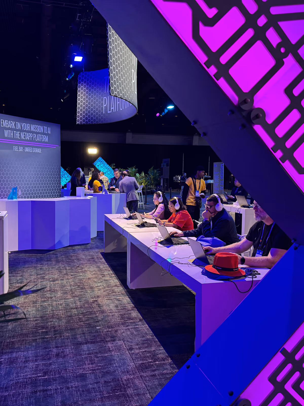 INSIGHT 2026 attendees in headphones working through demos on laptops at the Fuel Bay Unified Storage station